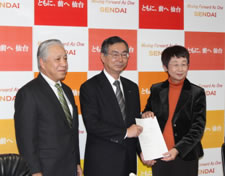 写真: 立地表明書を奥山仙台市長 (右) に手渡すKDDI小野寺会長 (中央) とKDDIエボルバ伊東社長 (左) = 仙台市役所本庁舎 (仙台市青葉区)